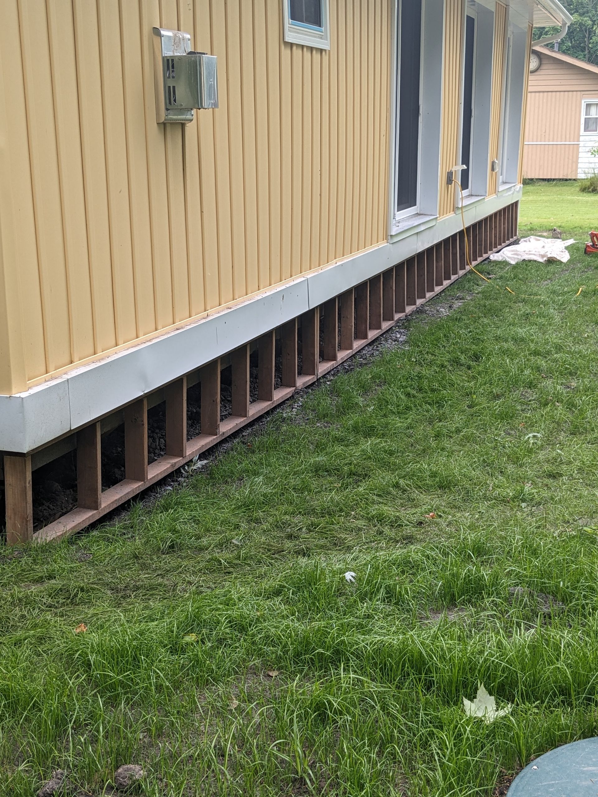 A yellow house is sitting on top of a lush green lawn.