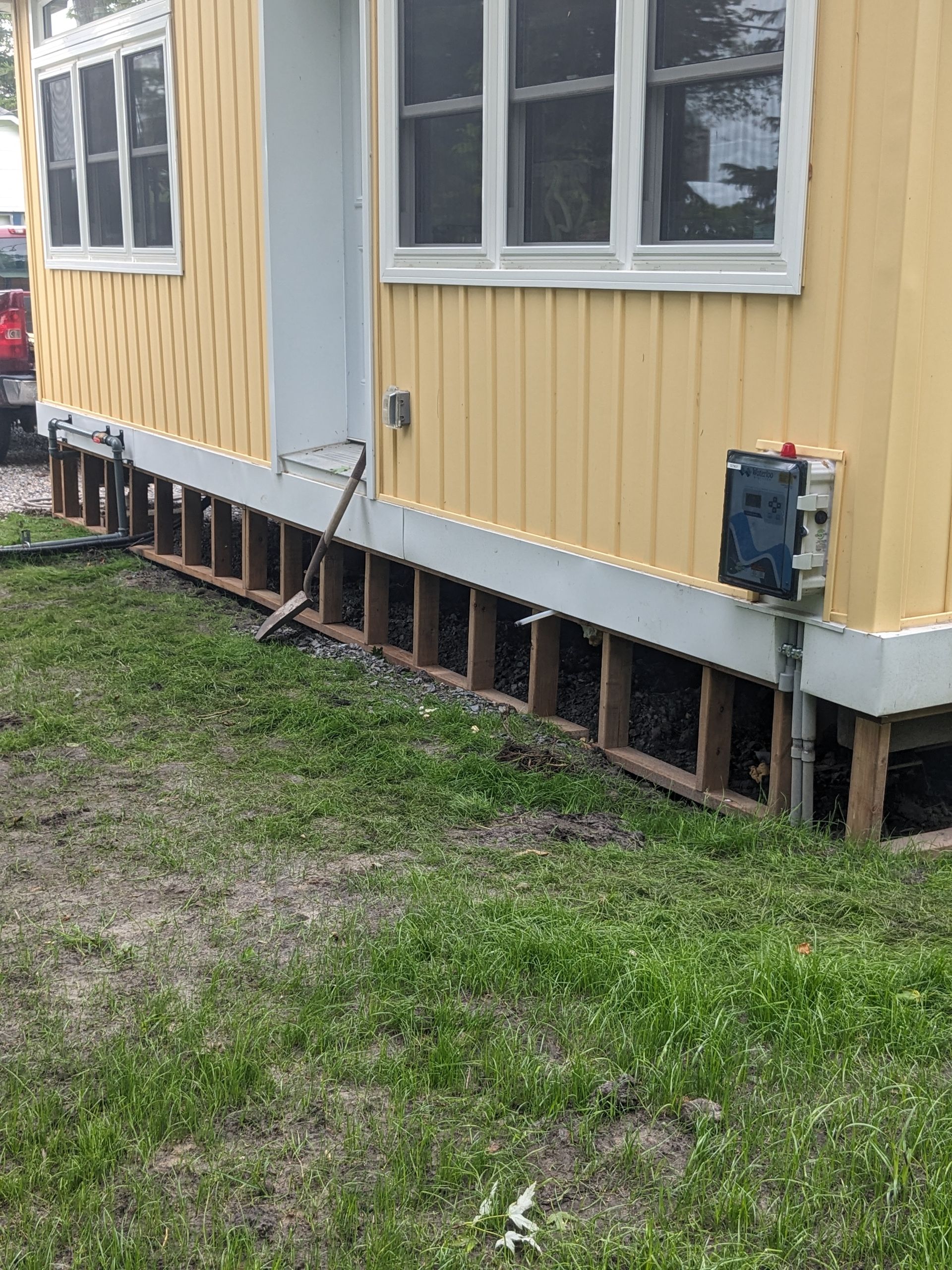A yellow house is sitting on top of a lush green lawn.