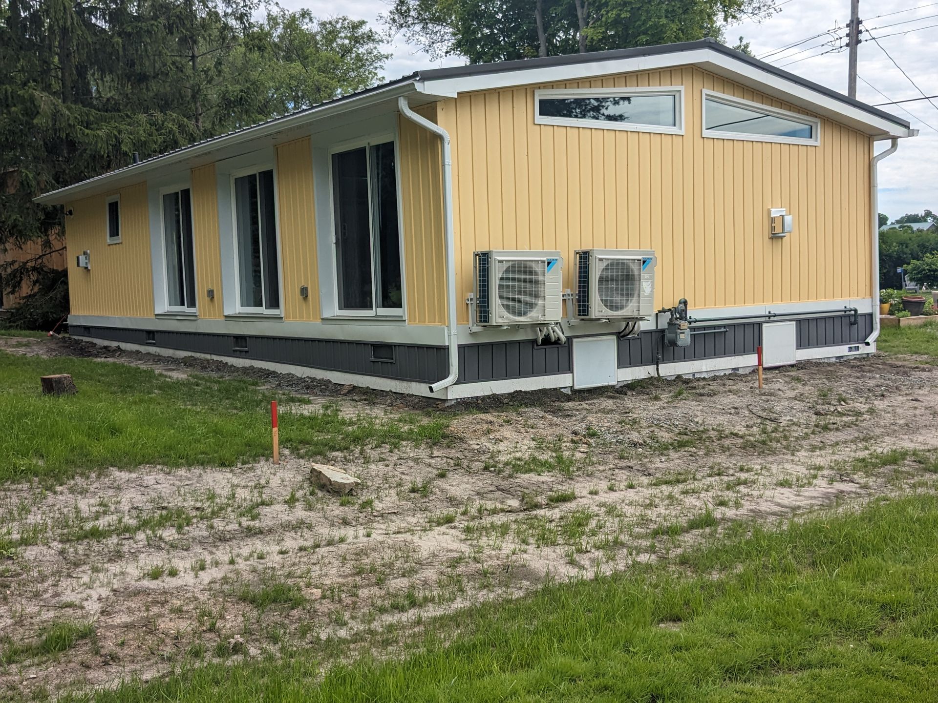 A yellow house with two air conditioners on the side of it