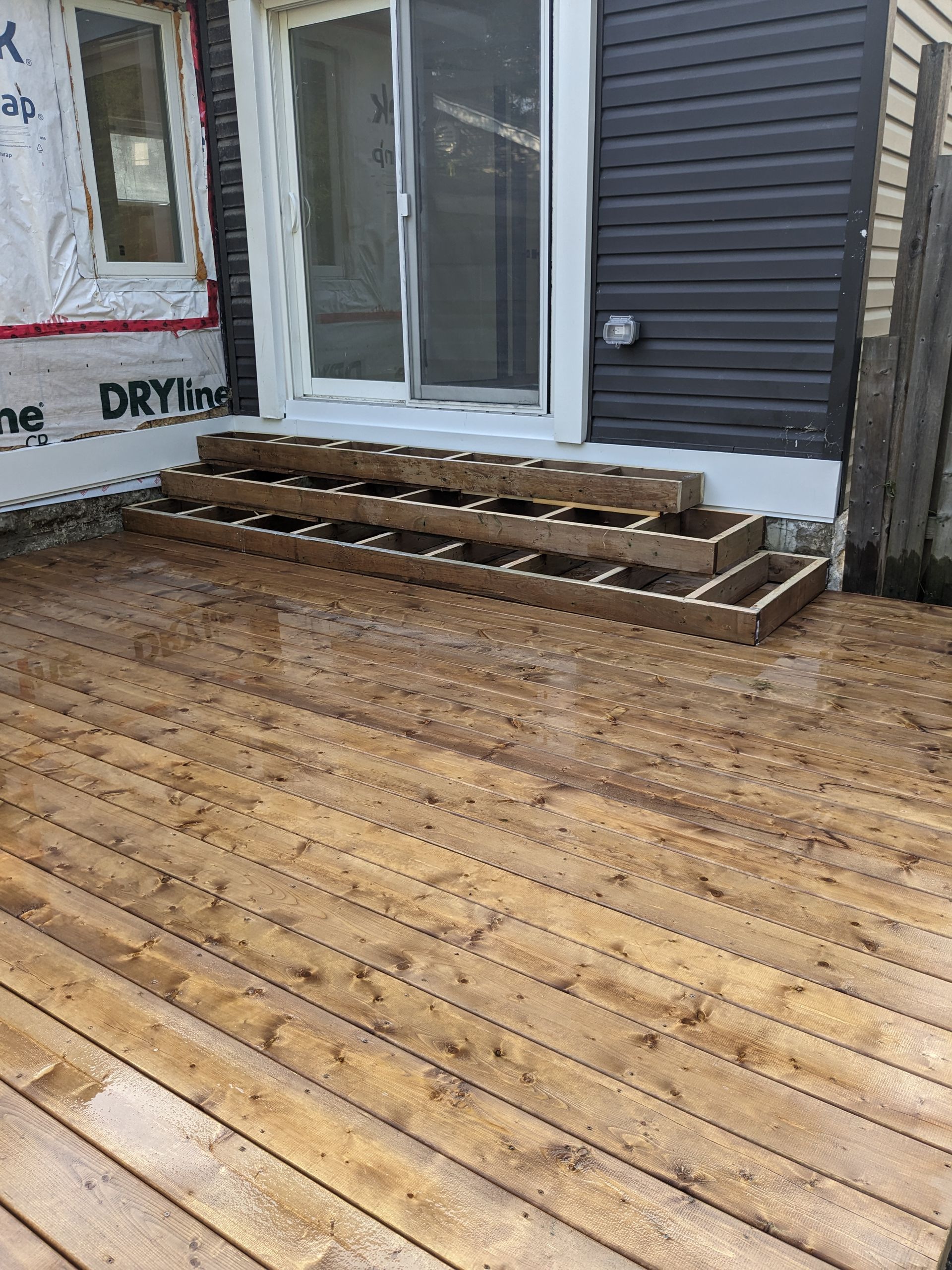 A wooden deck is being built in front of a house.