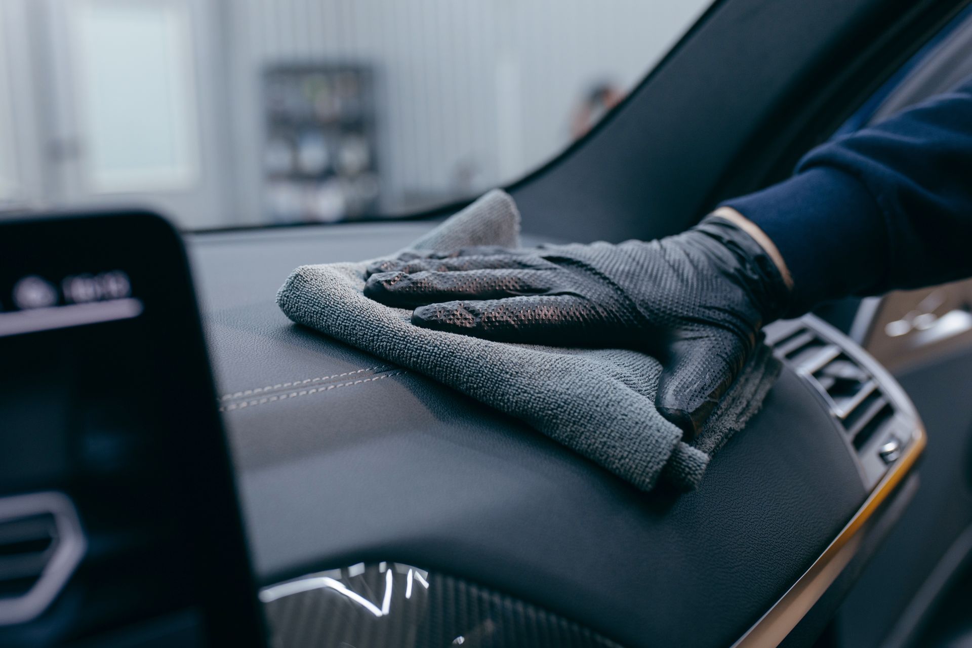 A black car seat organizer with tactical gear, including colored adhesive tape rolls and straps, hanging in a vehicle.