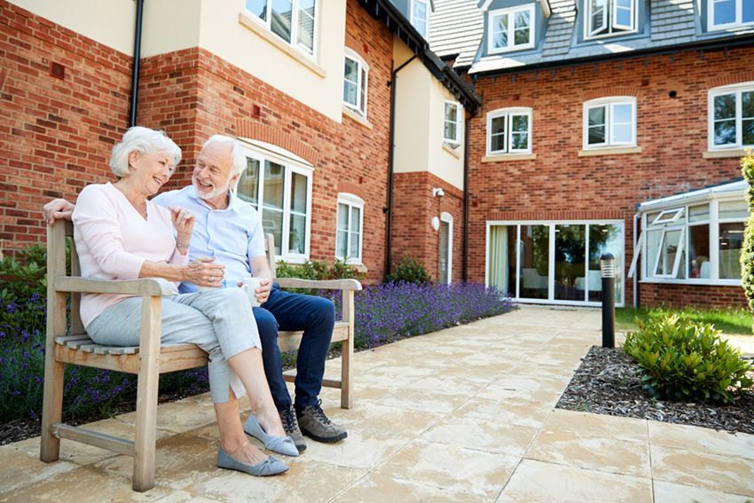 An Elderly Couple is Sitting on a Bench — Budd & Piper Solicitors & Conveyancers in Tweed Heads, NSW