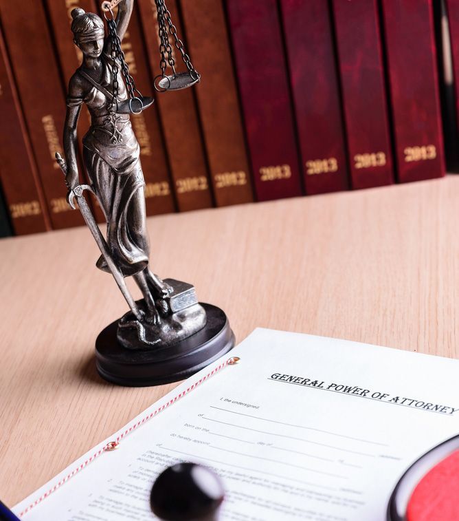 A Statue of Lady Justice Sits on a Piece of Paper — Budd & Piper Solicitors & Conveyancers in Tweed Heads, NSW