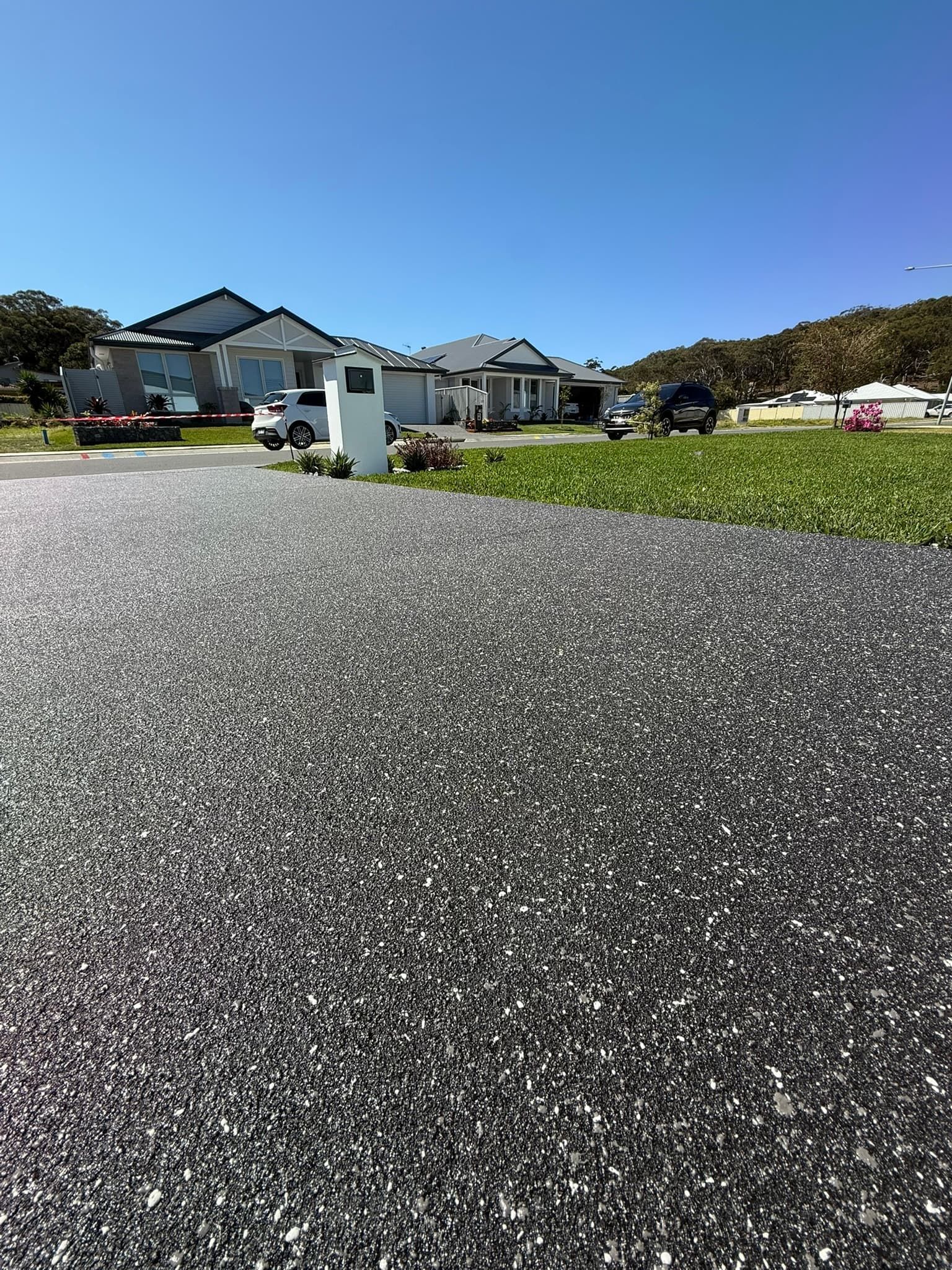 Black Speckled Driveway Leading to Suburban Homes — Port Macquarie Concrete Resurfacing in Port Macquarie, NSW 