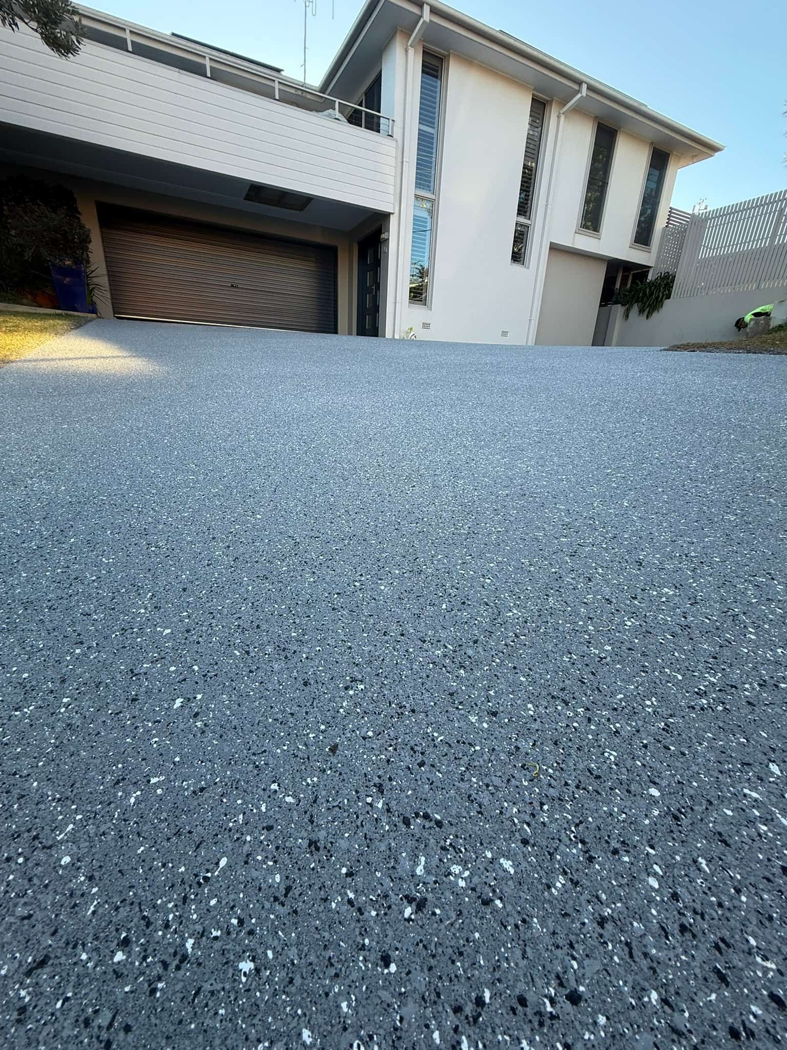 Driveway Leading to A White House with A Garage — Port Macquarie Concrete Resurfacing in Port Macquarie, NSW