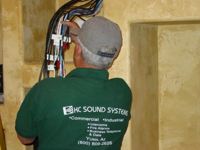 A man wearing a green shirt that says hc sound systems.