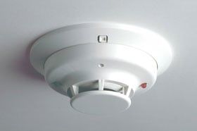 A white smoke detector is mounted to the ceiling.