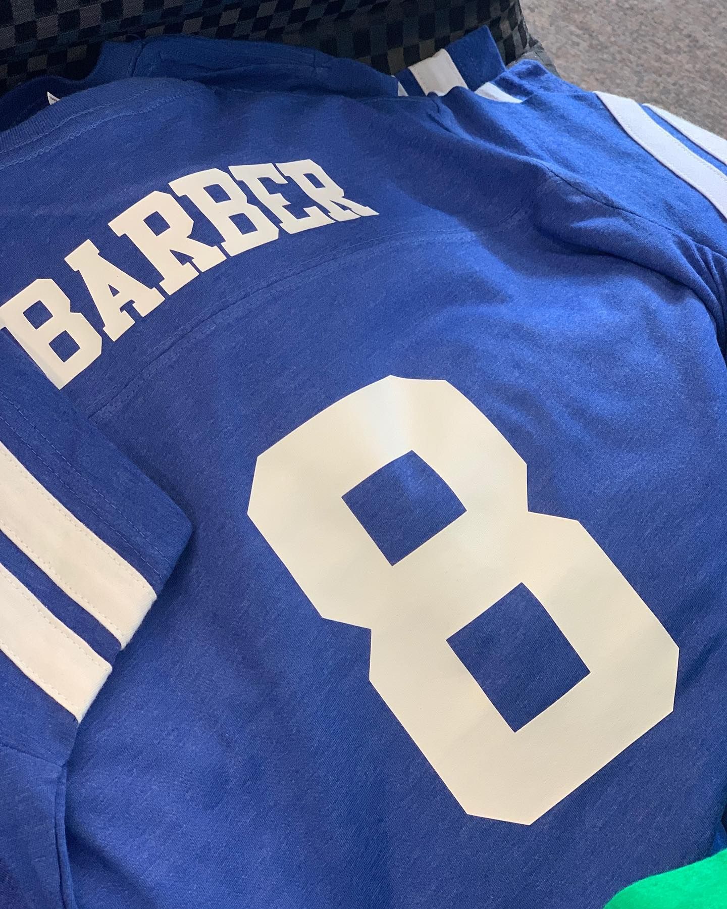 A blue jersey with the name barber and the number 8 on it
