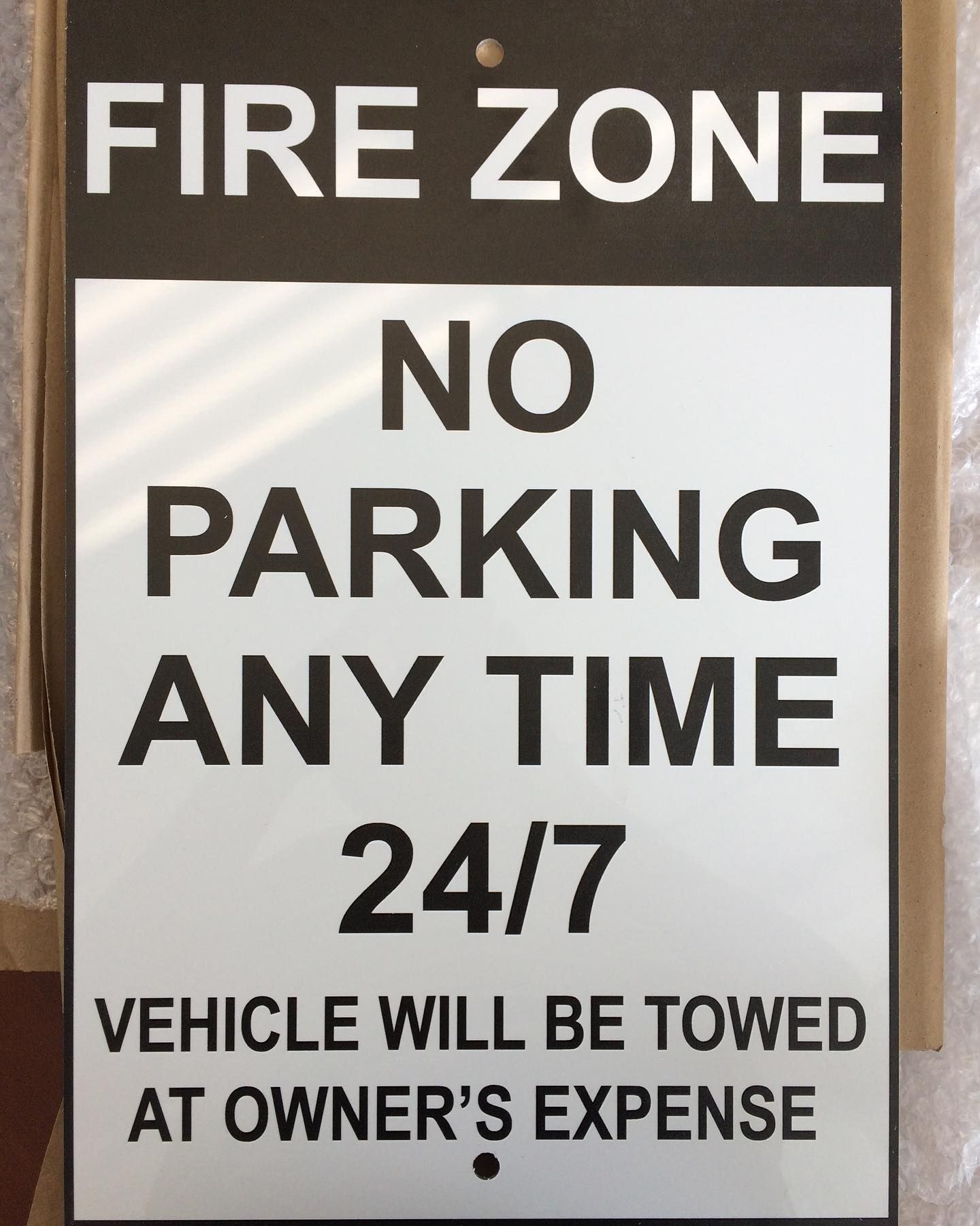 A sign that says fire zone no parking any time 24/7