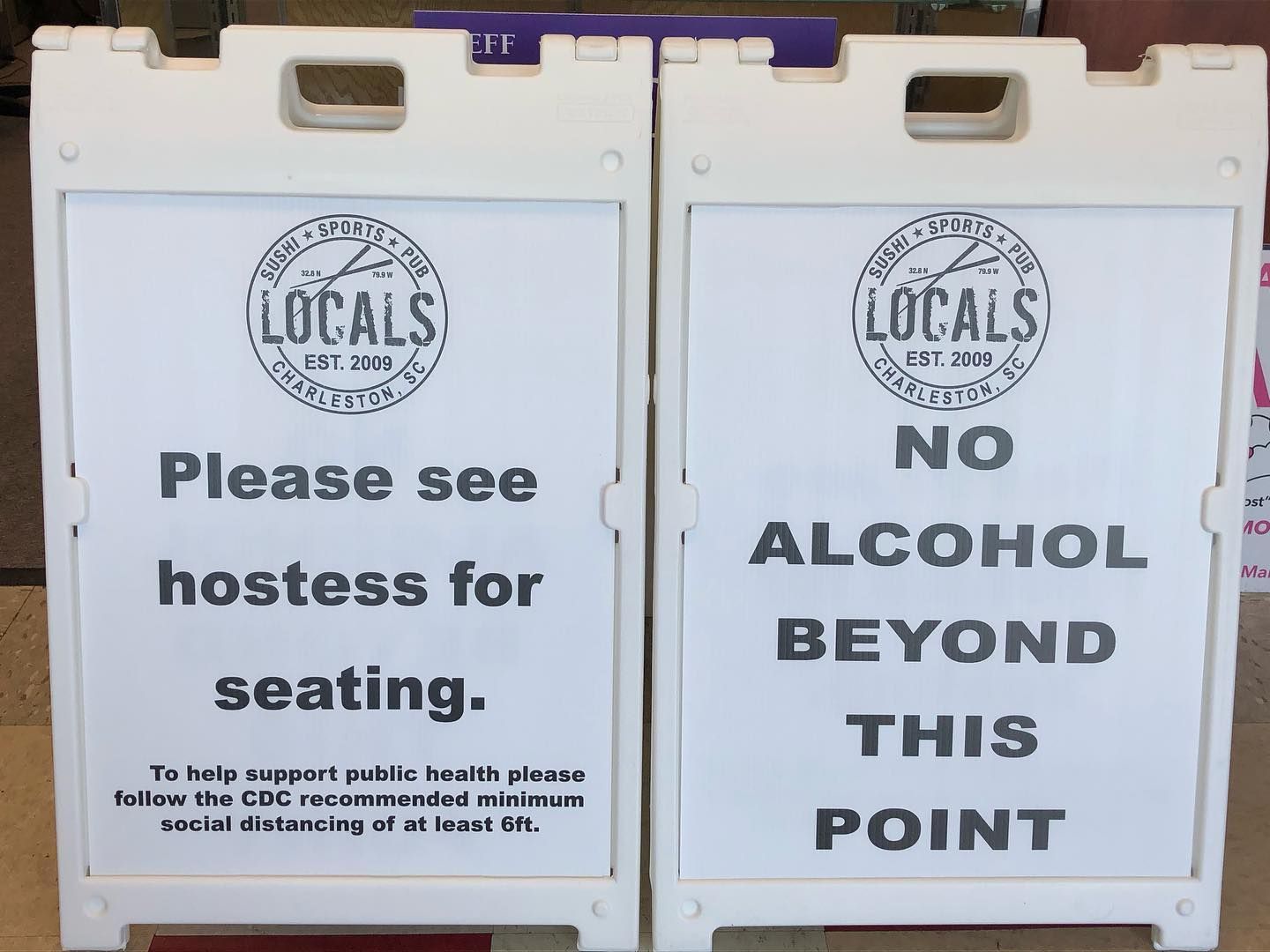 Two signs that say please see hostess for seating and no alcohol beyond this point