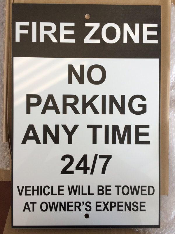 A sign that says fire zone no parking any time 24/7