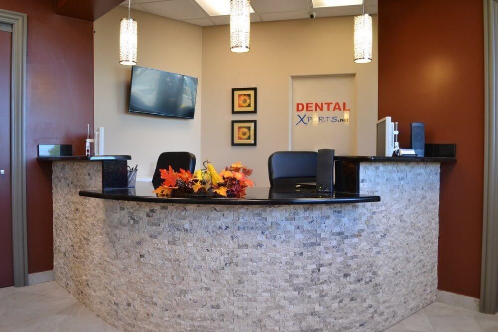 A dental office with a reception desk and chairs