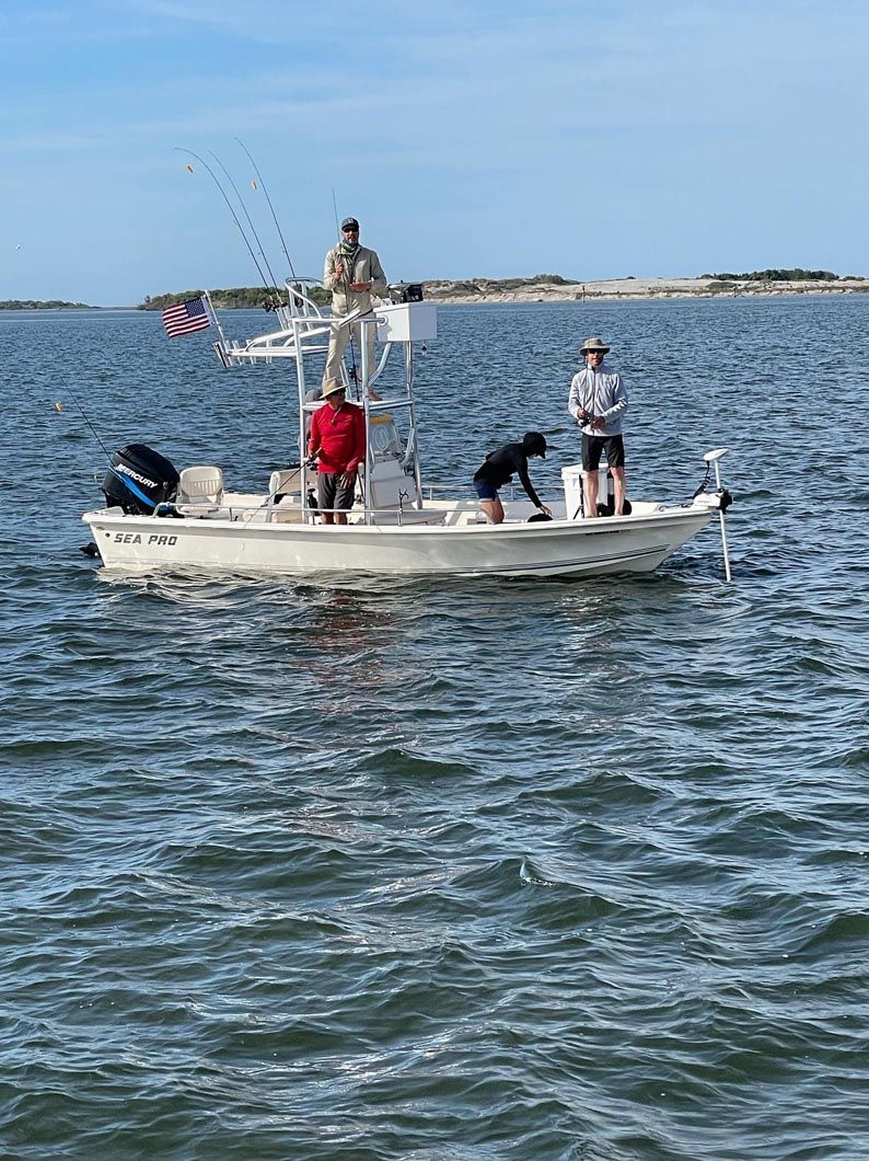 A group of people are fishing on a boat in the ocean.