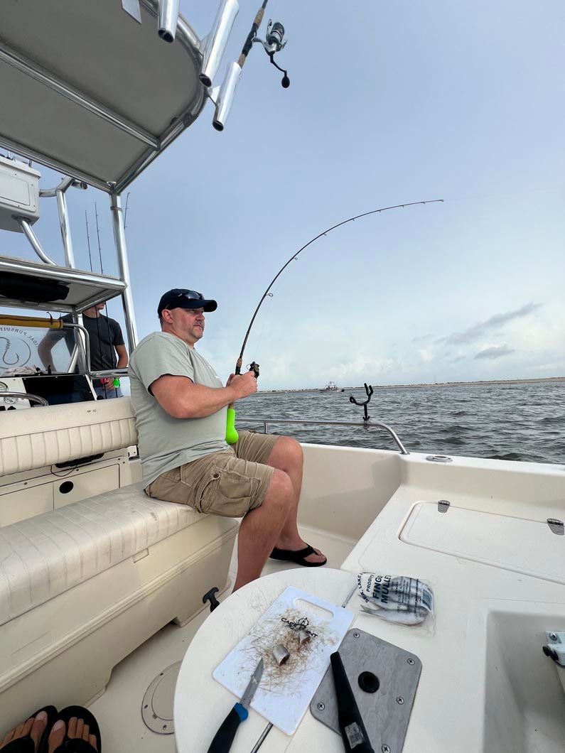 A man is fishing on a boat in the ocean