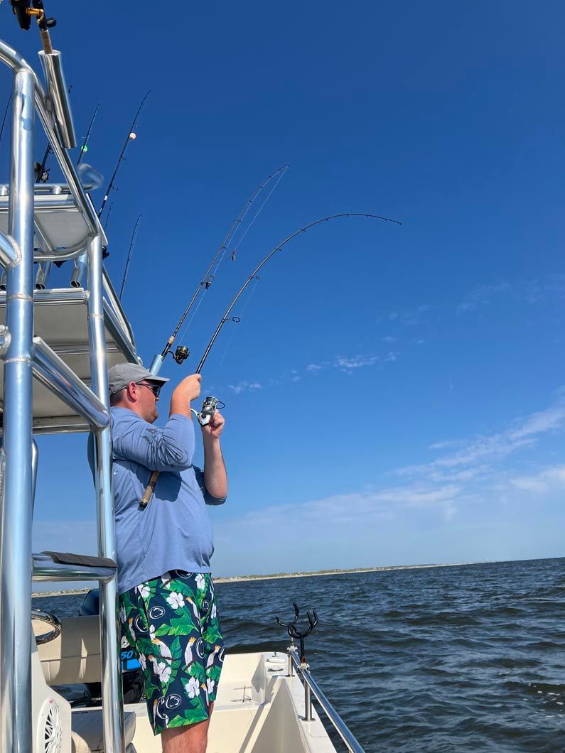 A man is fishing on a boat in the ocean.
