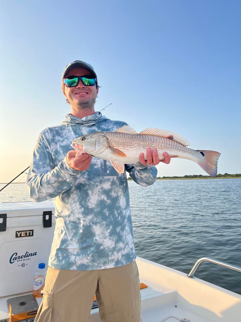 A man is holding a large fish on a boat.