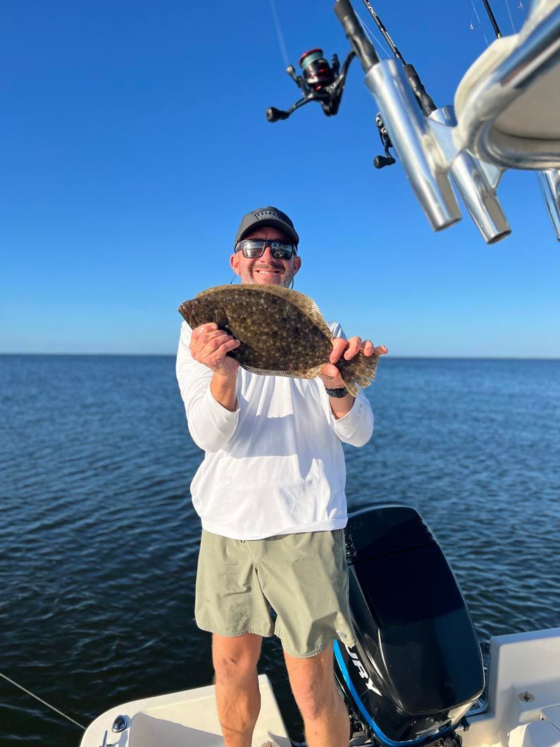 A man is standing on a boat holding a fish in his hands.
