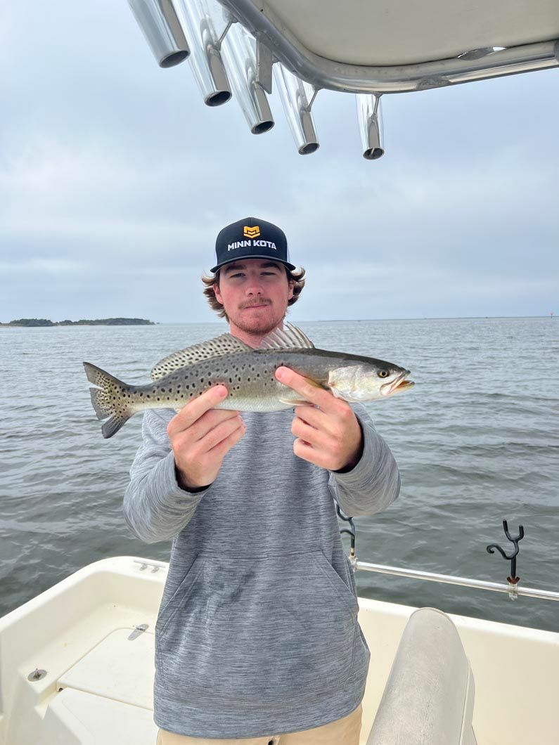 A man is holding a fish on a boat.