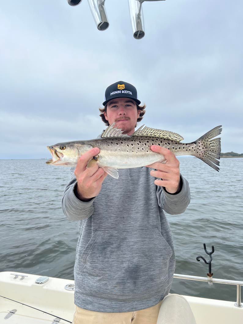 A man is holding a fish in his hands on a boat.