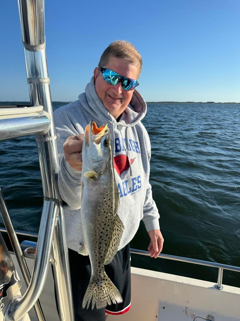 A man is holding a fish on a boat.