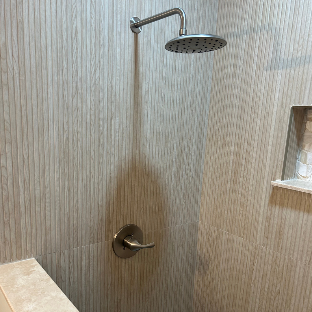 A shower head is hanging from the wall in a bathroom.