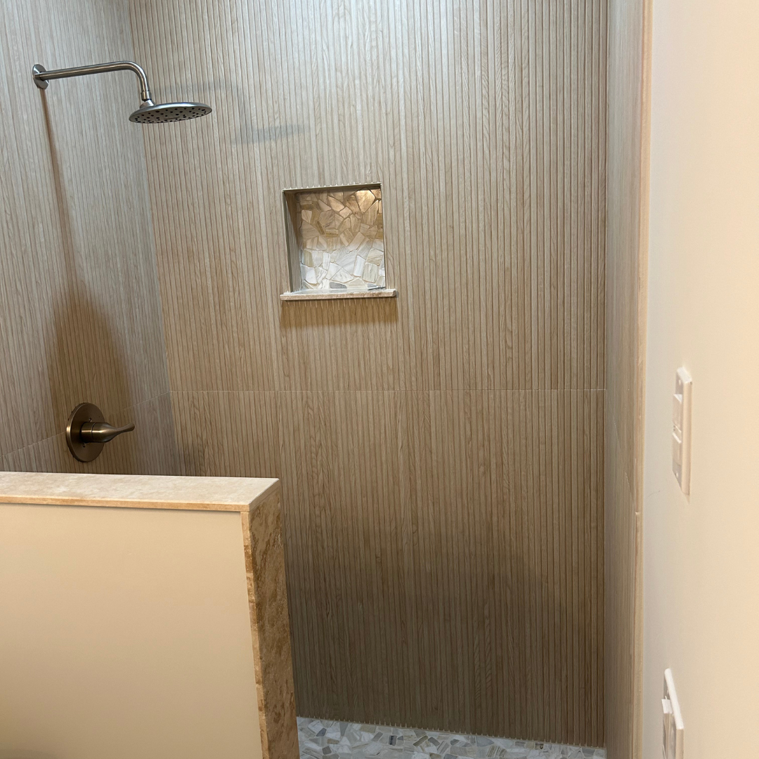 A bathroom with a walk in shower and a shower head.