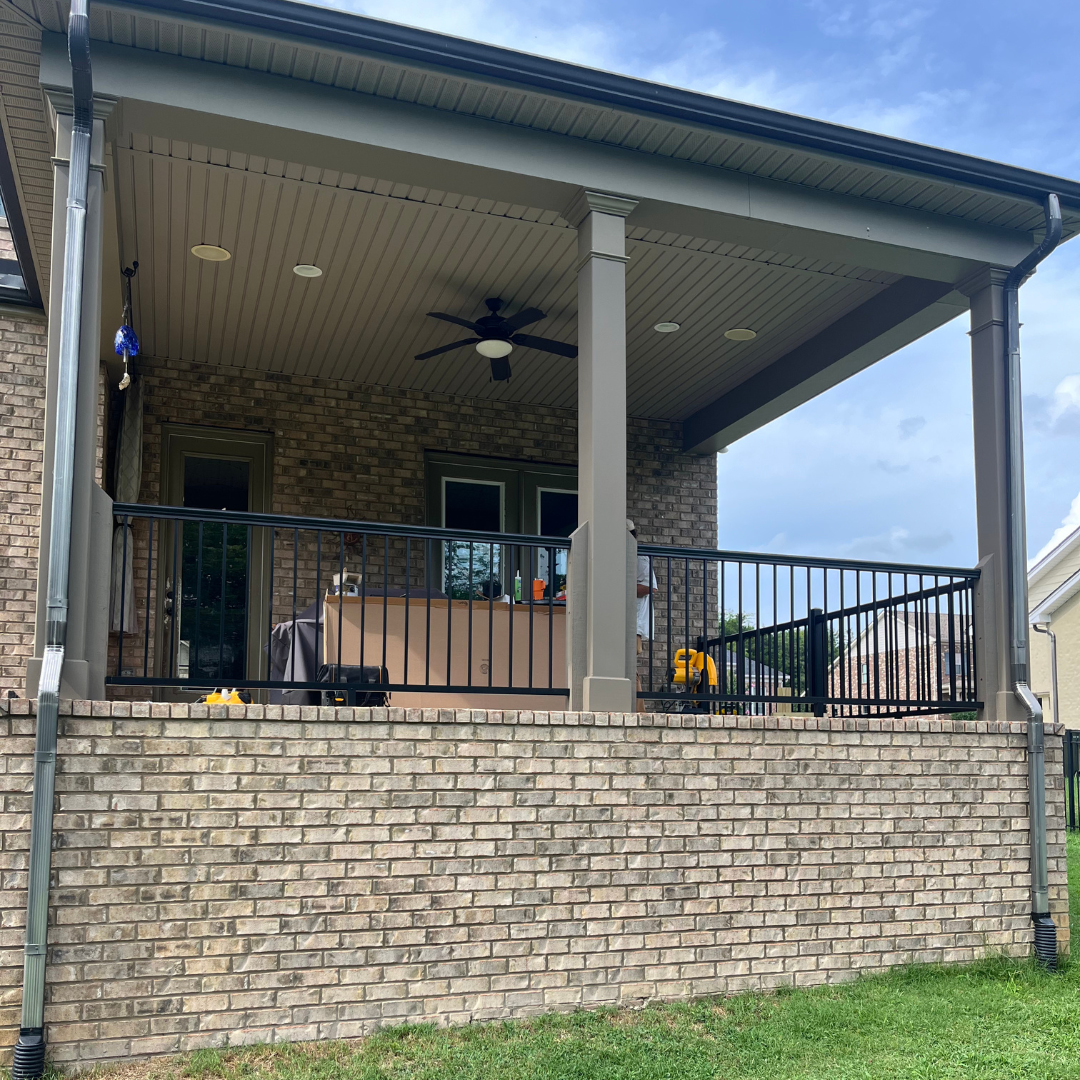 A brick house with a porch and a ceiling fan