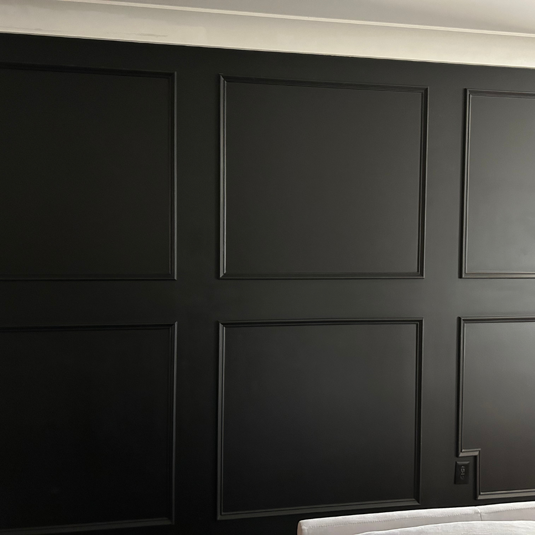 A bedroom with black walls and a white couch.