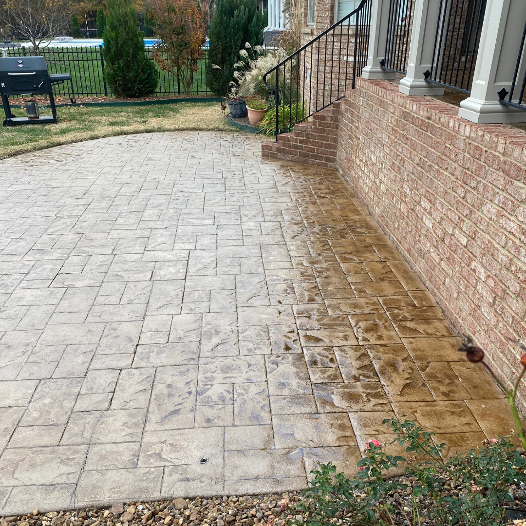 A brick building with a patio and stairs in front of it.