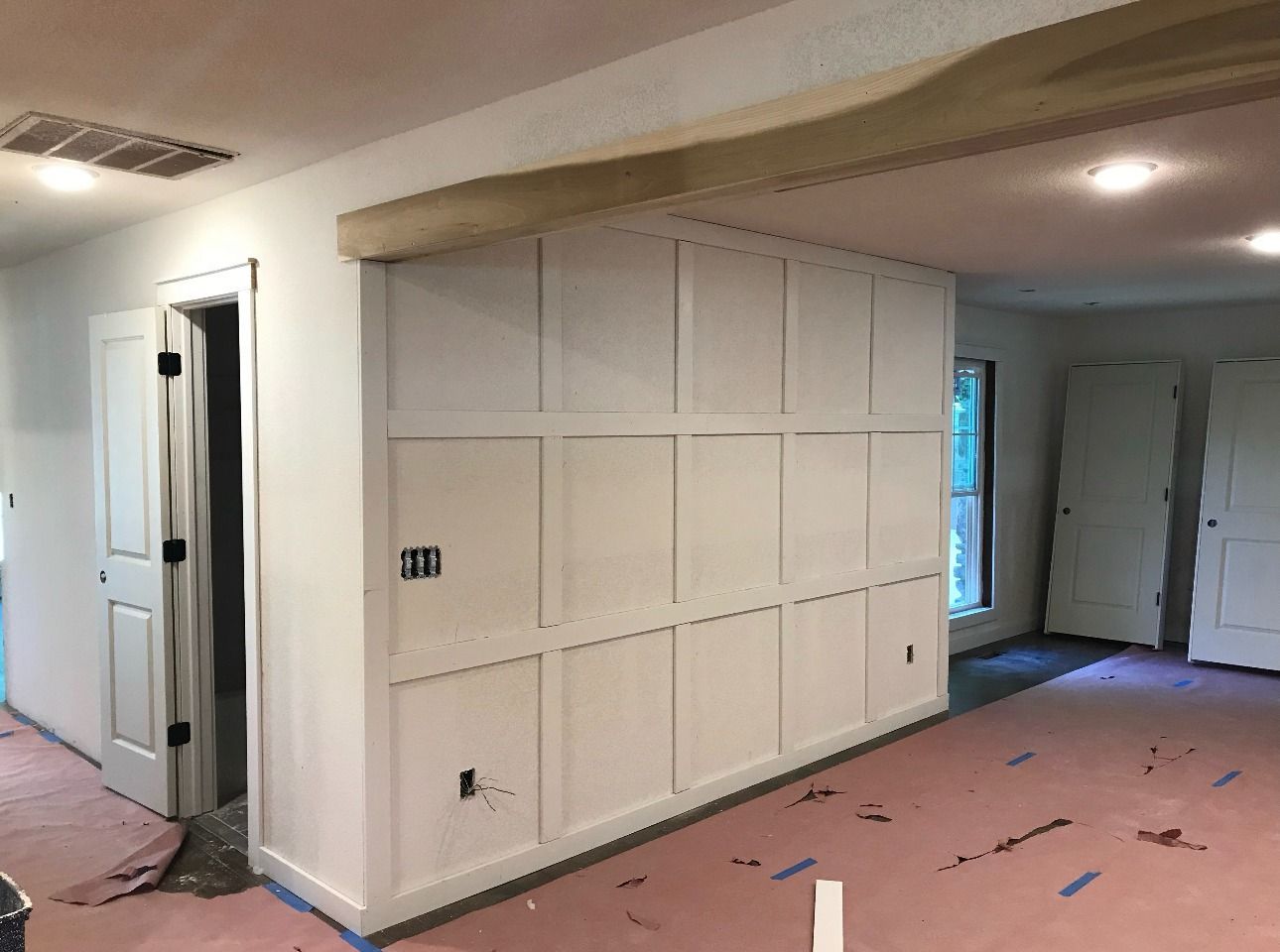 A room with white walls and pink carpet is being painted.