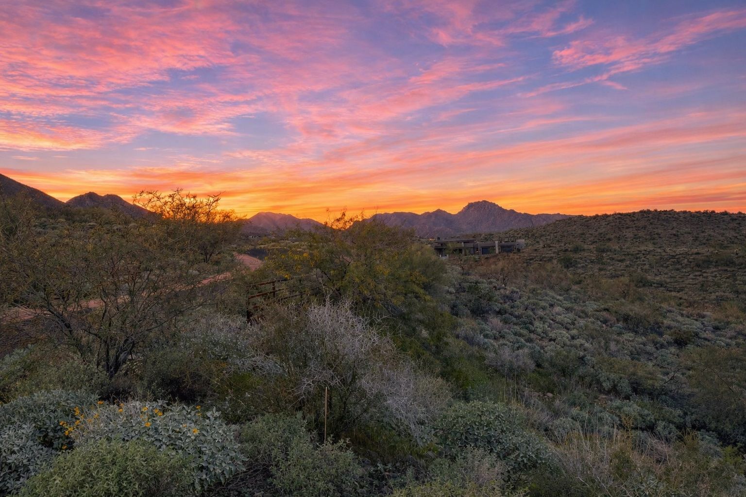 Sunset over desert landscape with pink, orange, and purple sky. Lot for sale in Eagle's Nest