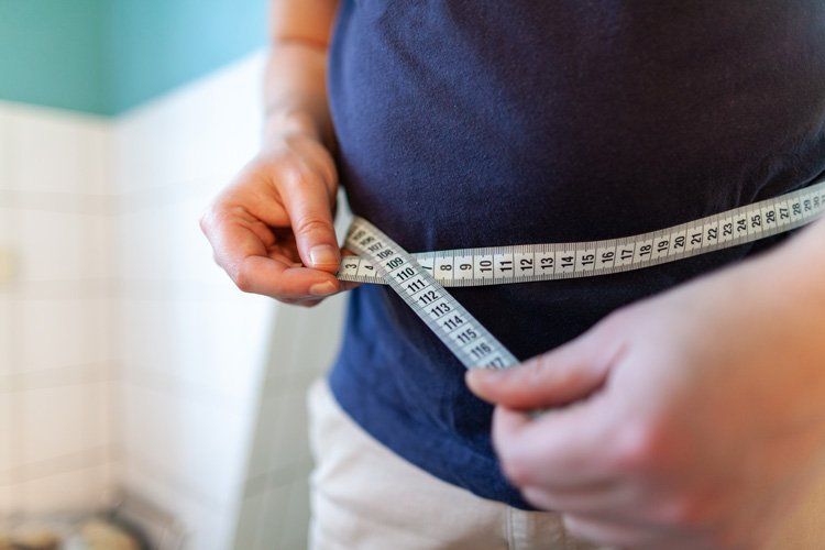 Man Measuring His Waist Using a Tape Measure — Orlando, FL — Jack G. Faup, M.D.