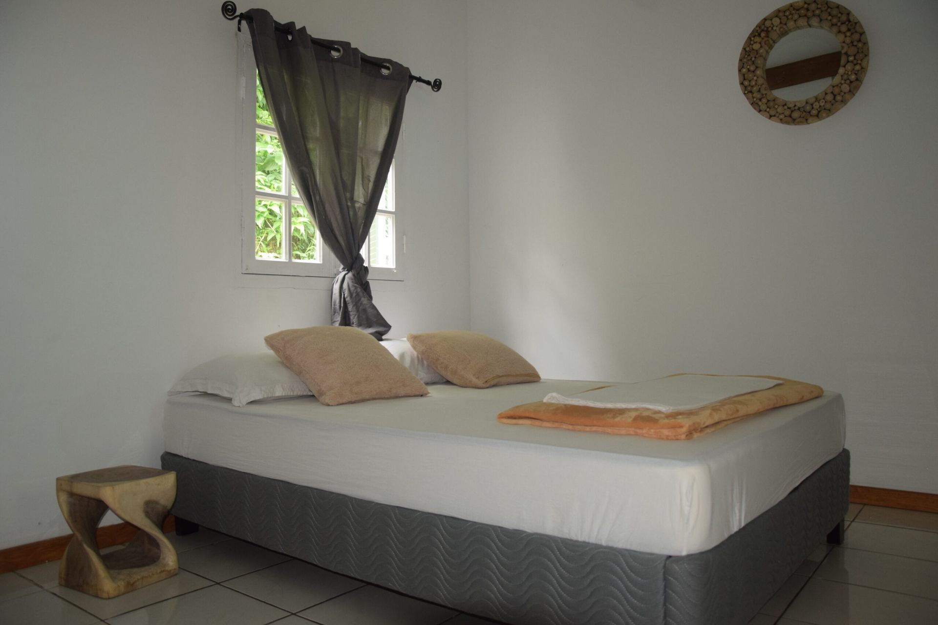 Une chambre avec un lit, une table de nuit et une fenêtre.