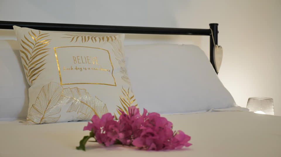 Un lit avec un oreiller et des fleurs dessus.