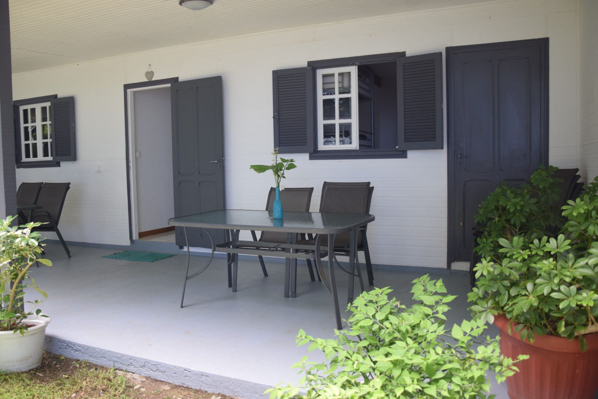 Il y a une table et des chaises sur le porche d'une maison.