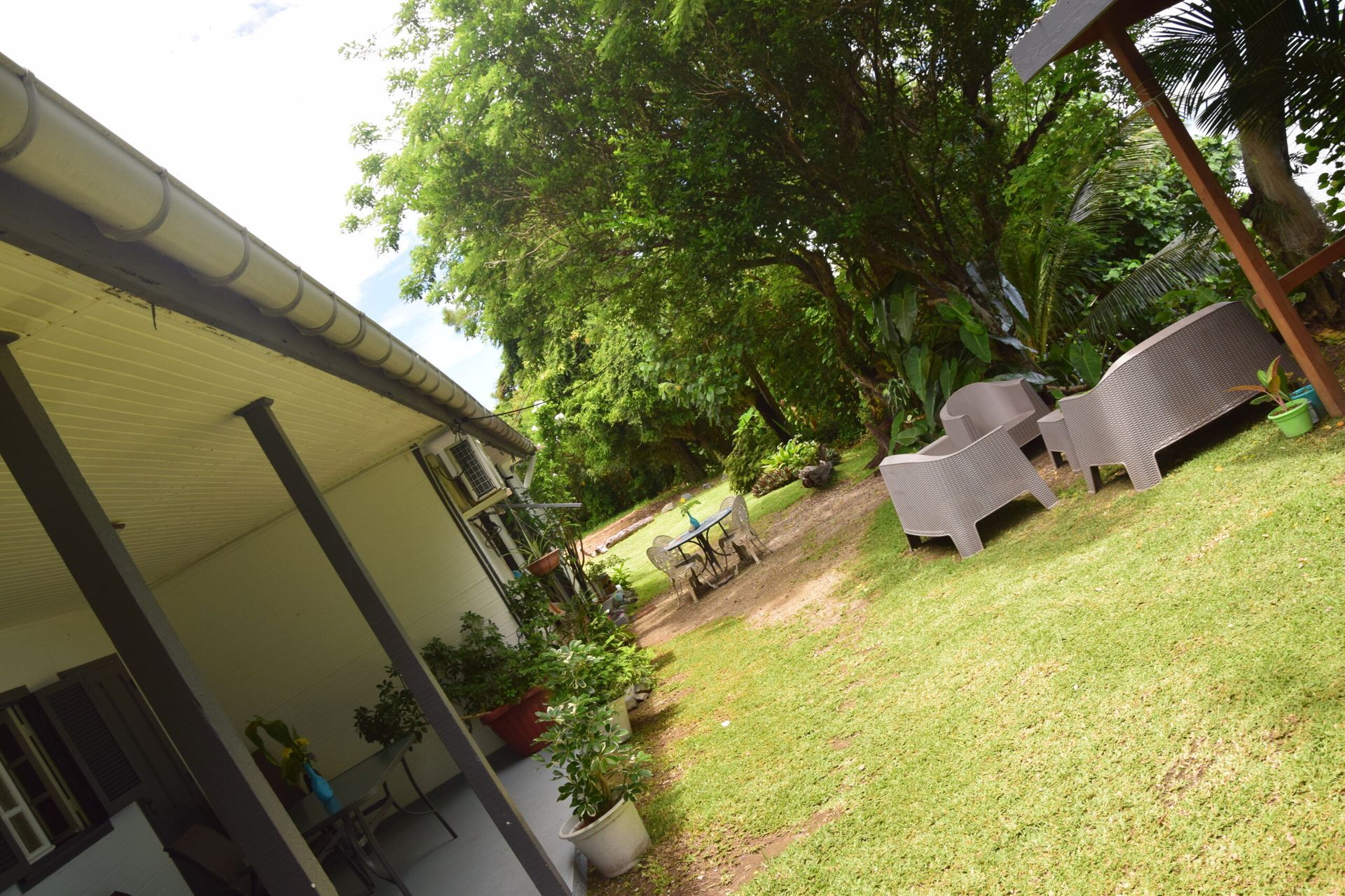 Une pelouse avec des chaises et une table devant une maison