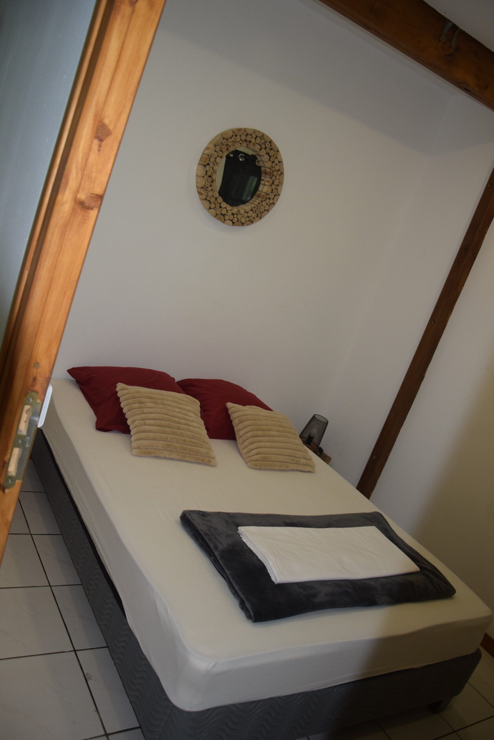 Une chambre avec un lit et un miroir au mur