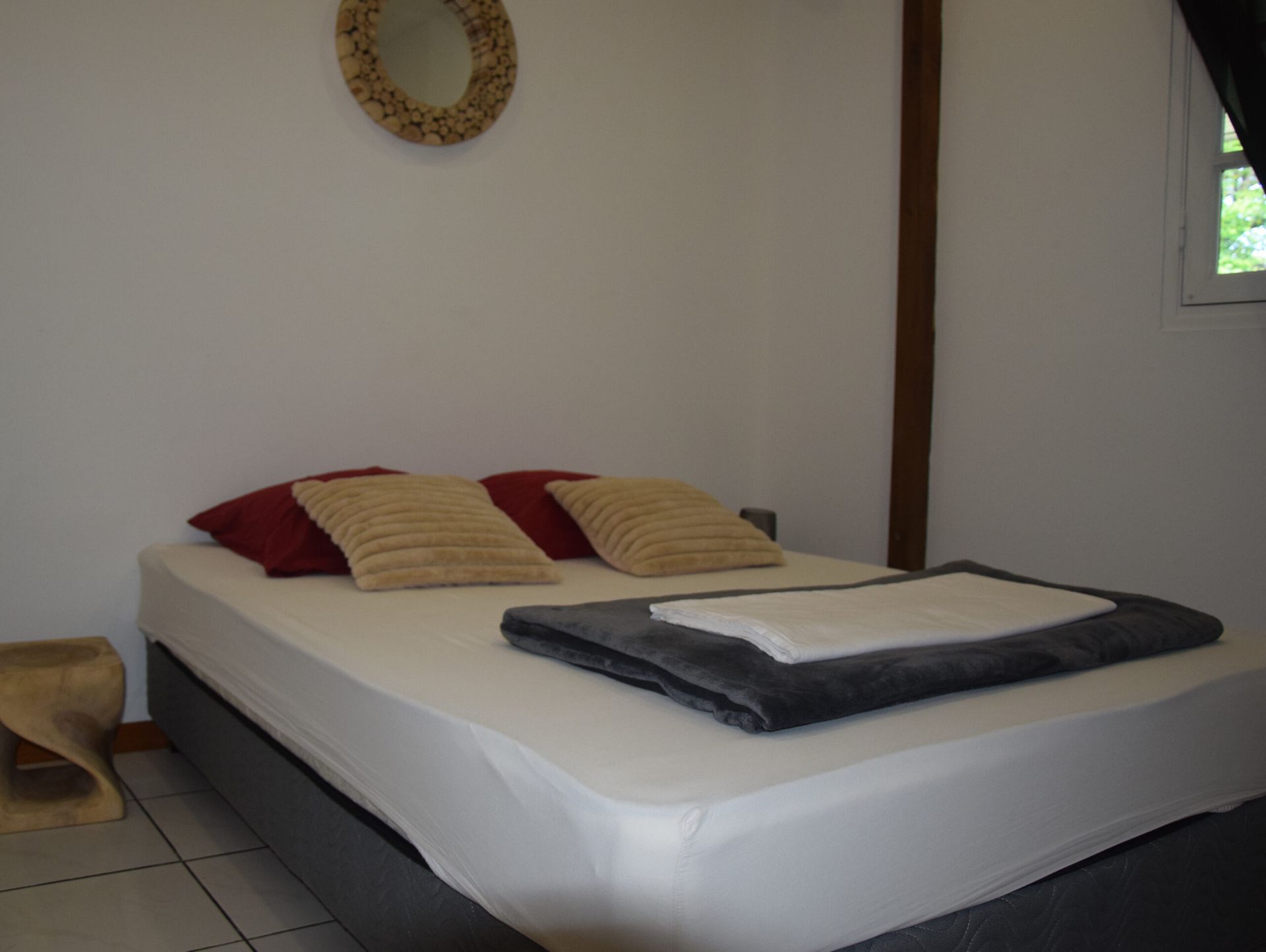 Une chambre avec un lit et un miroir au mur