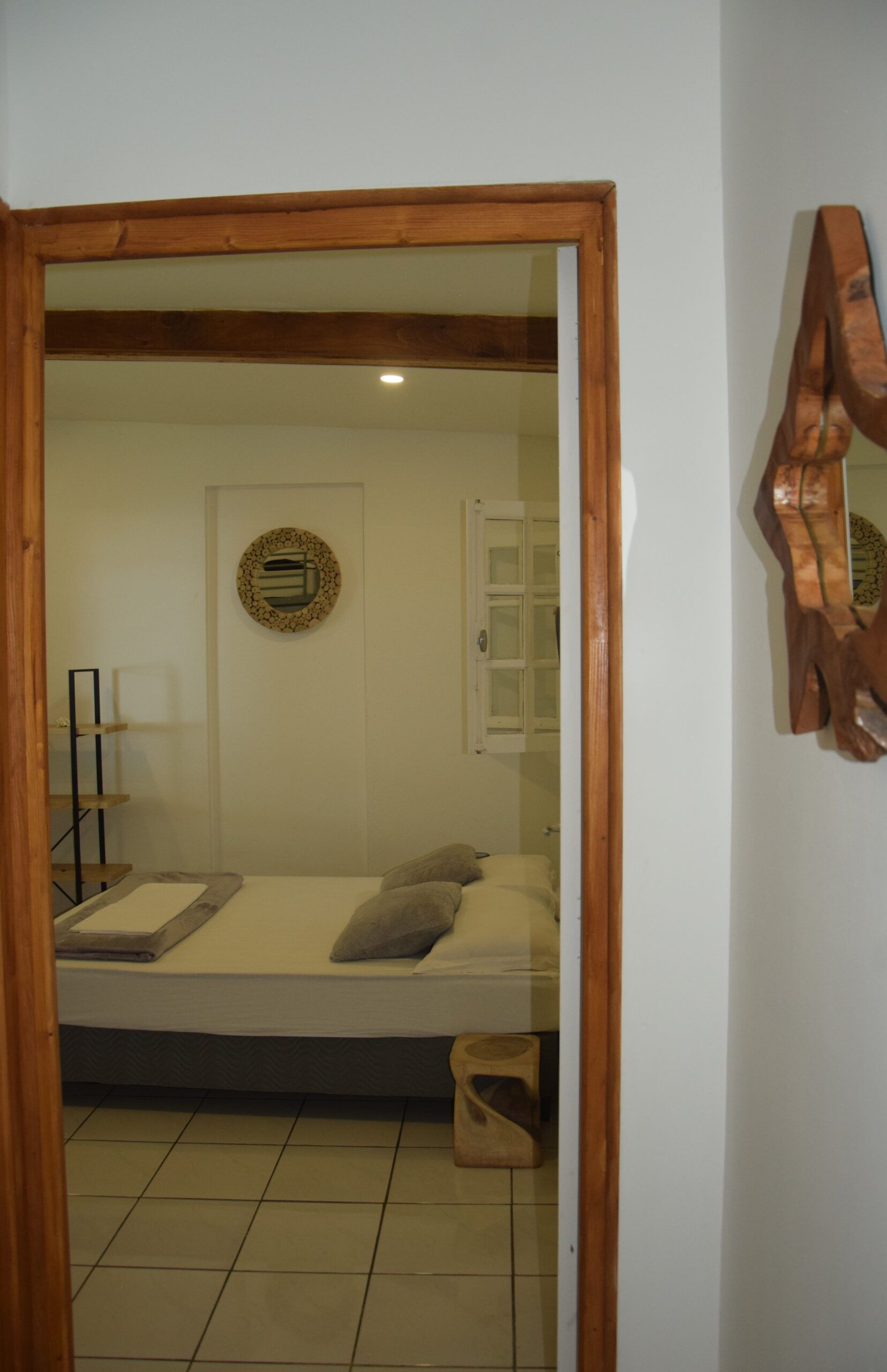 Une chambre avec un lit et un miroir au mur.