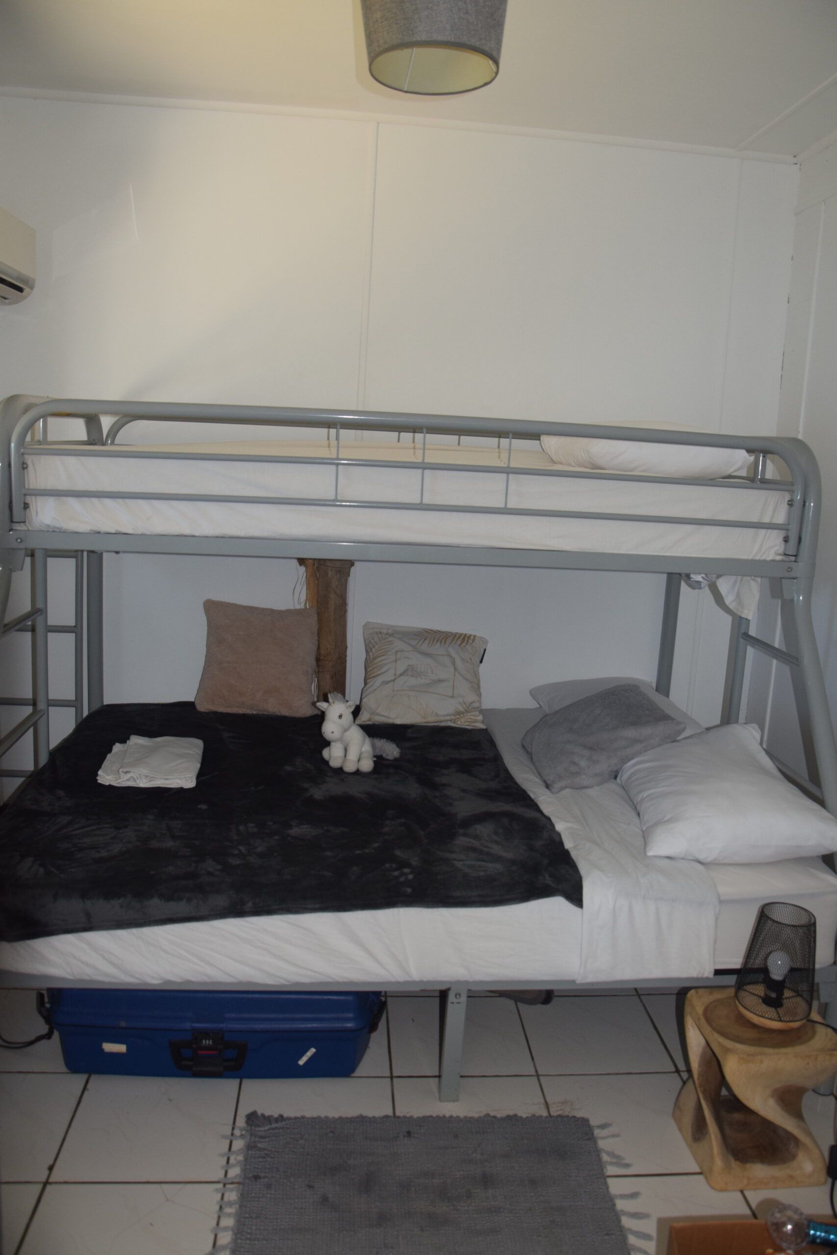 Un lit superposé avec un animal en peluche dessus dans une chambre.