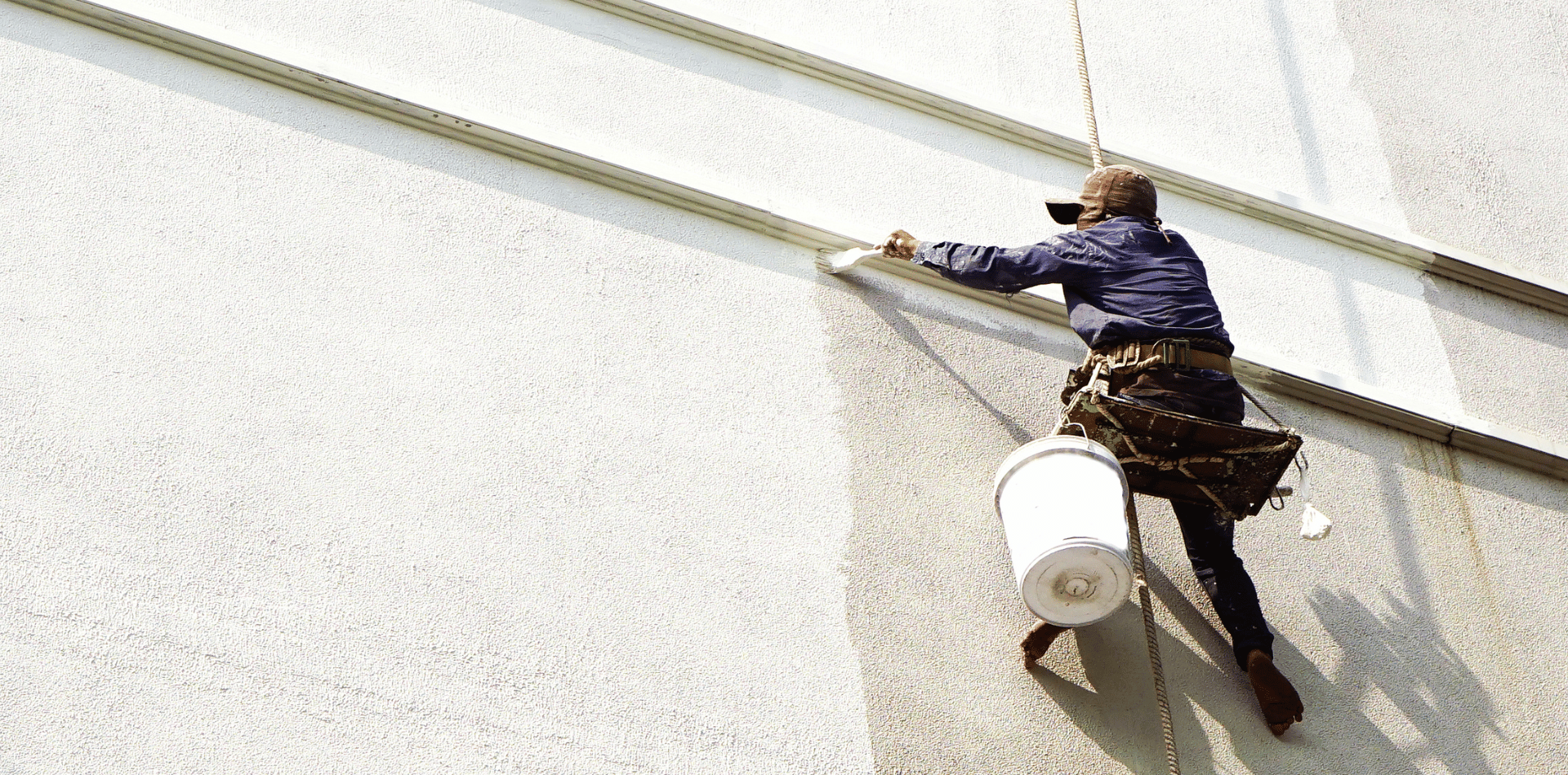 A professional painter painting an exterior wall