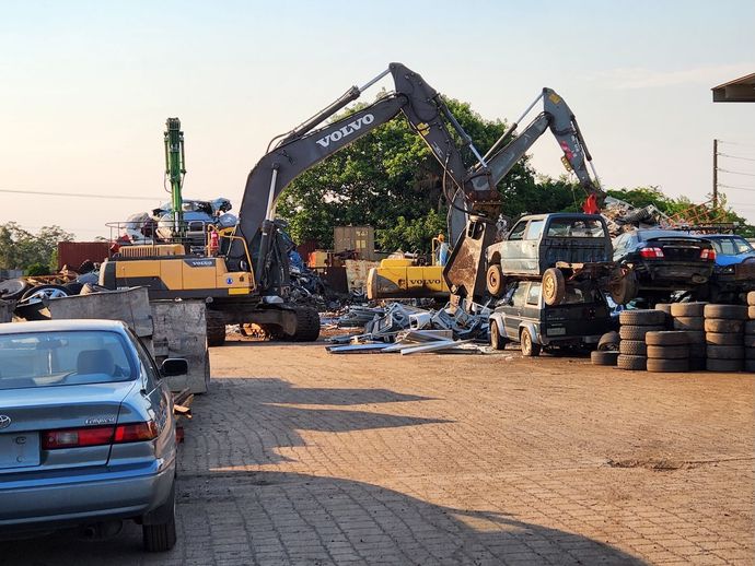 Red Excavator is Working on a Pile of Scrap Metal — Maryborough Recycling in Maryborough, QLD