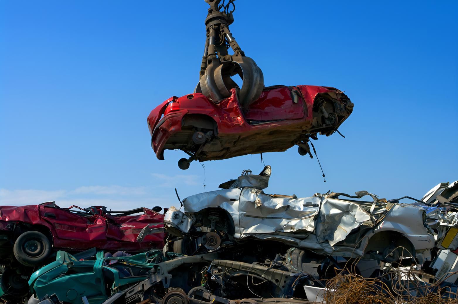 Red Car is Being Lifted Into the Air by a Crane — Maryborough Recycling in Tin Can Bay, QLD