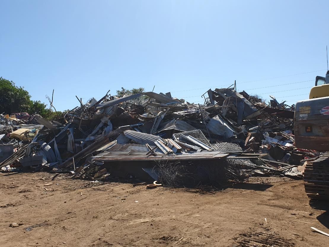 Large Pile of Scrap Metal is Sitting on Top of a Dirt Field — Maryborough Recycling in Maryborough, QLD