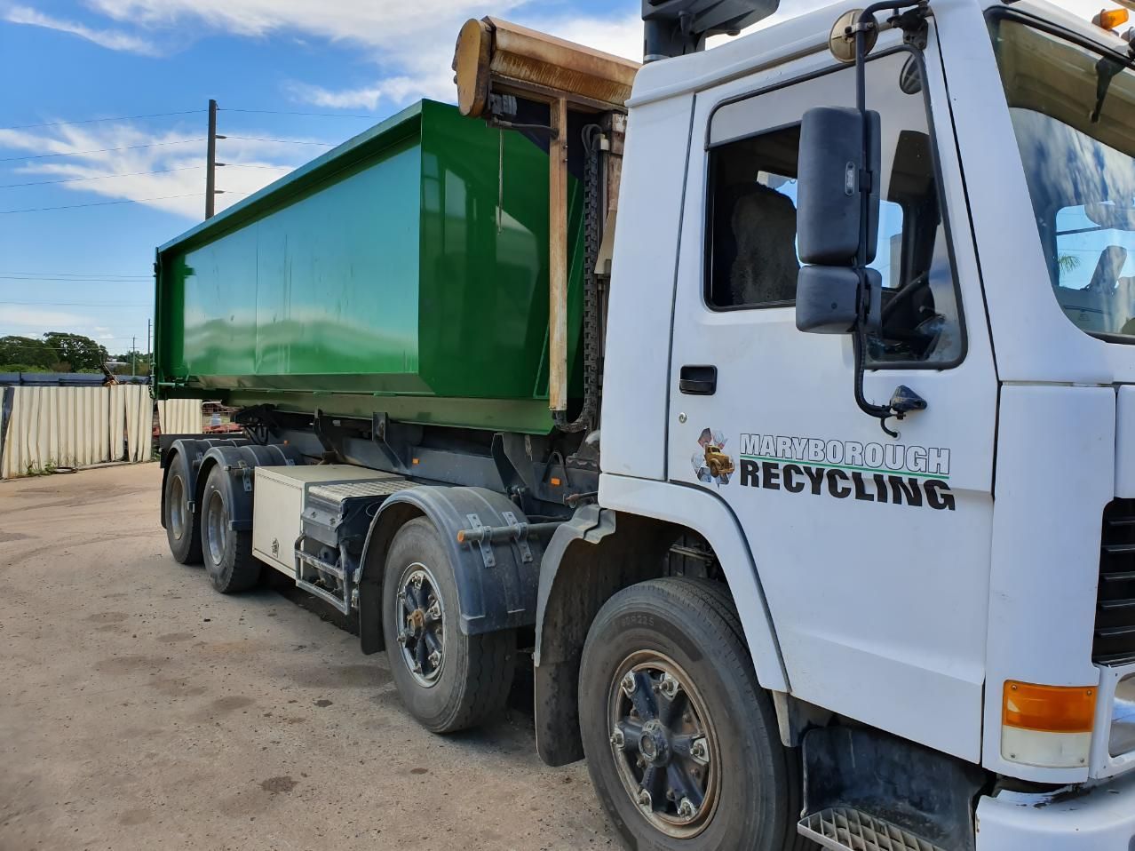 White Truck With a Green Dumpster on the Back is Parked — Maryborough Recycling in Maryborough, QLD