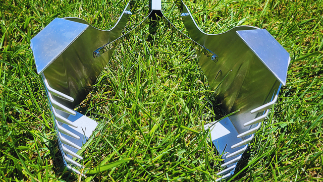 A metal object is sitting on top of a lush green field.