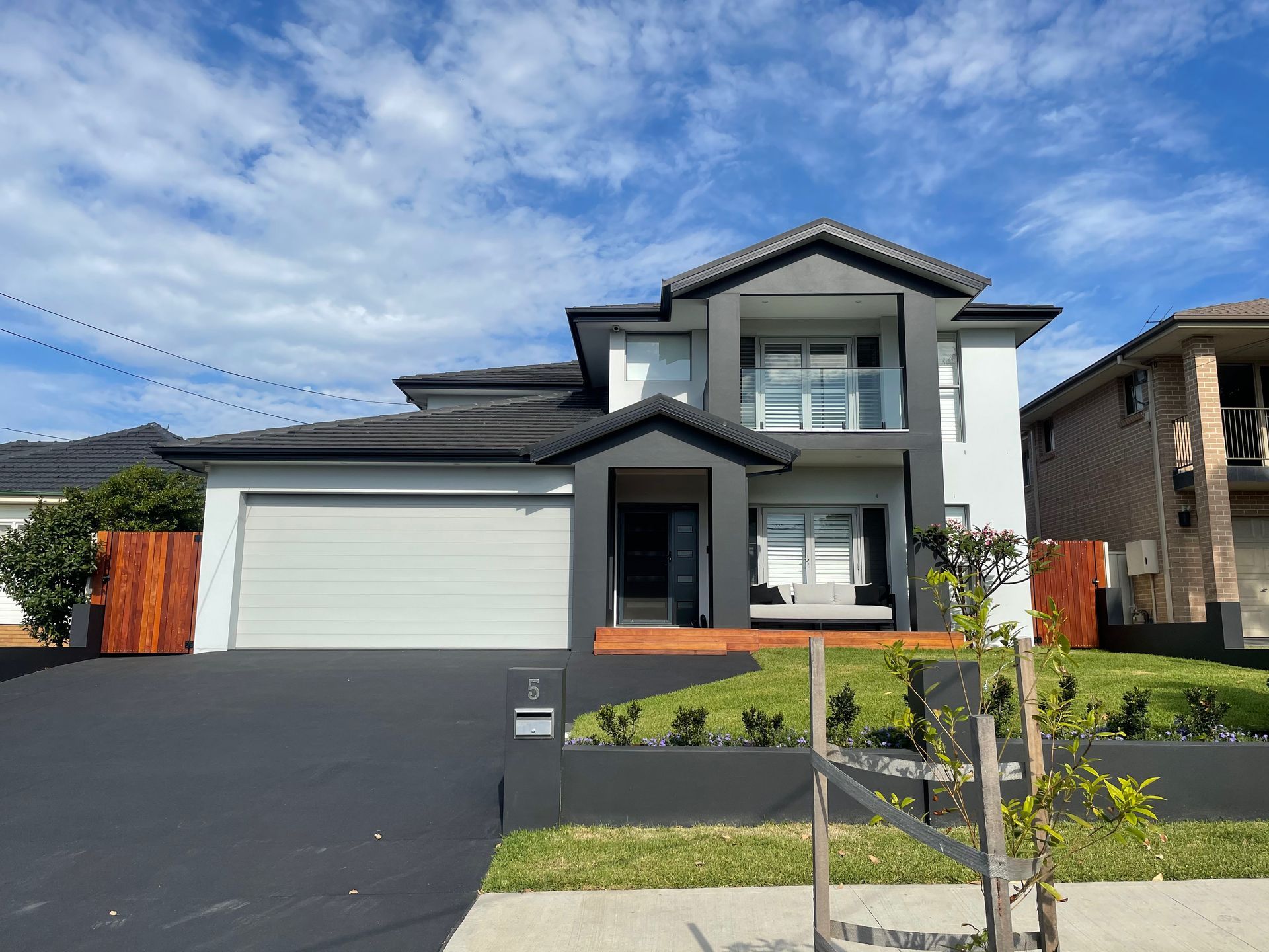 painter and decorators in a white room, one worker pouring green paint into a paint tray