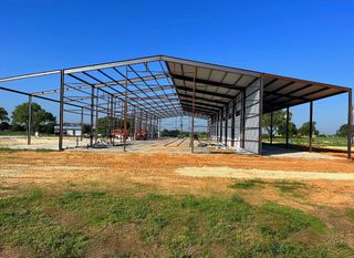 A large metal structure is being built in a field.