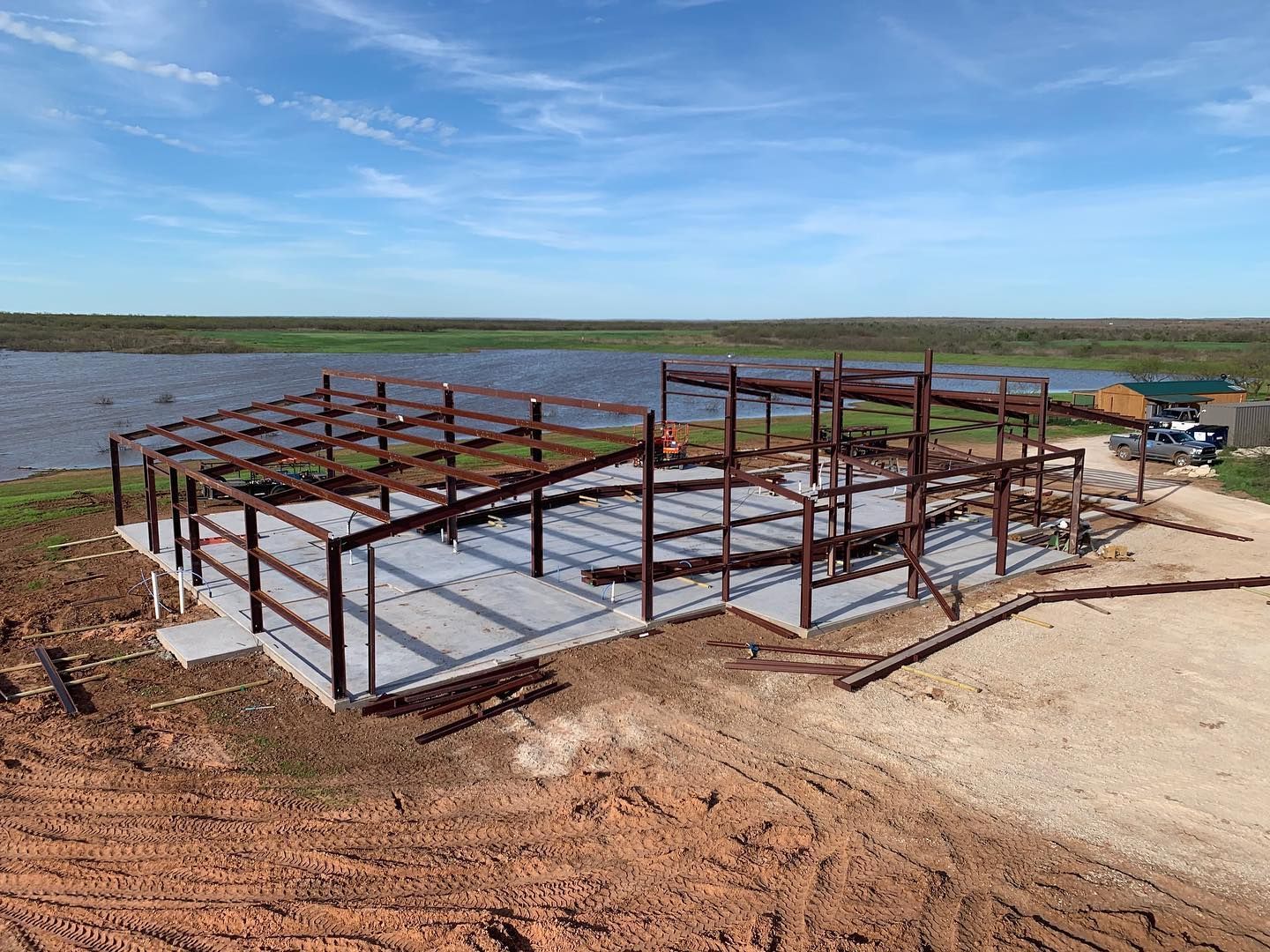 An aerial view of a building under construction next to a body of water.