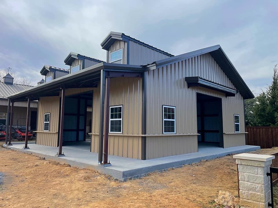 A large metal building with a porch and a garage.